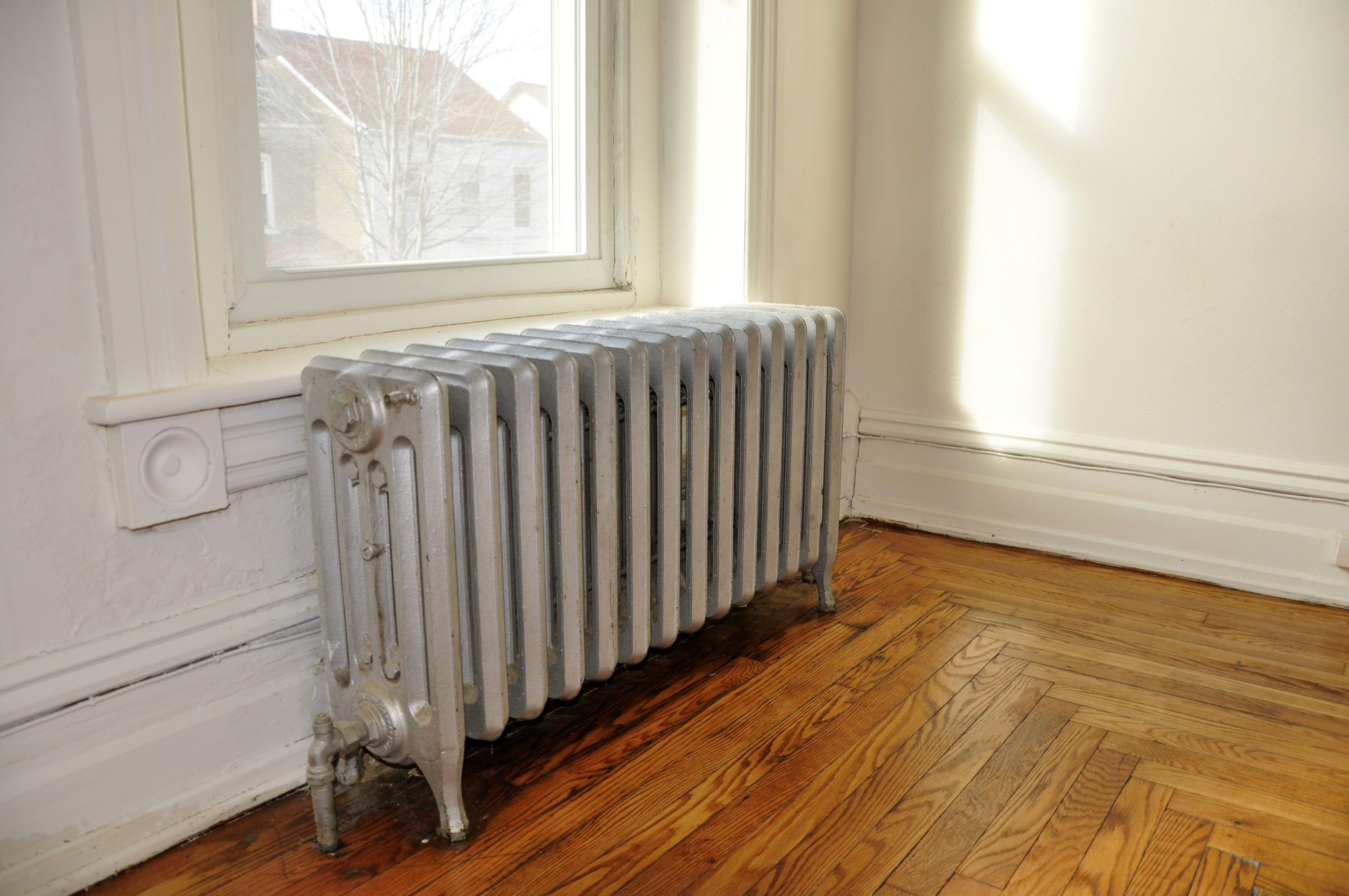 A radiator in a old home next to a window